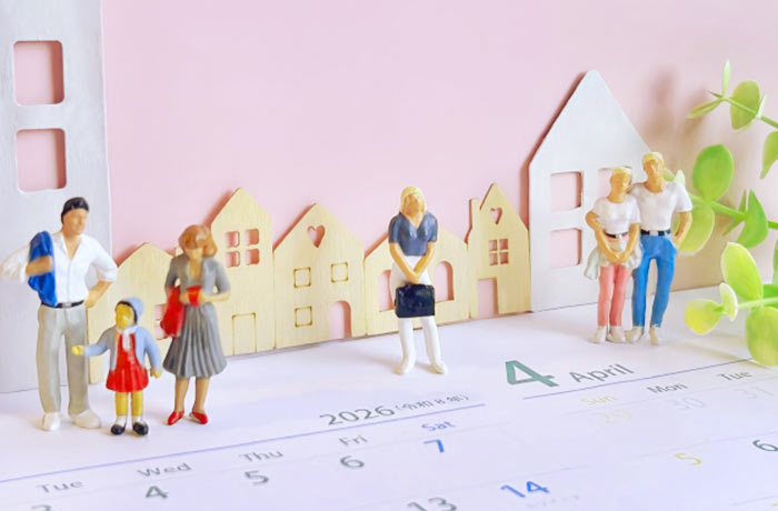 春の新生活シーズンをイメージしたミニチュアの家族と住宅模型